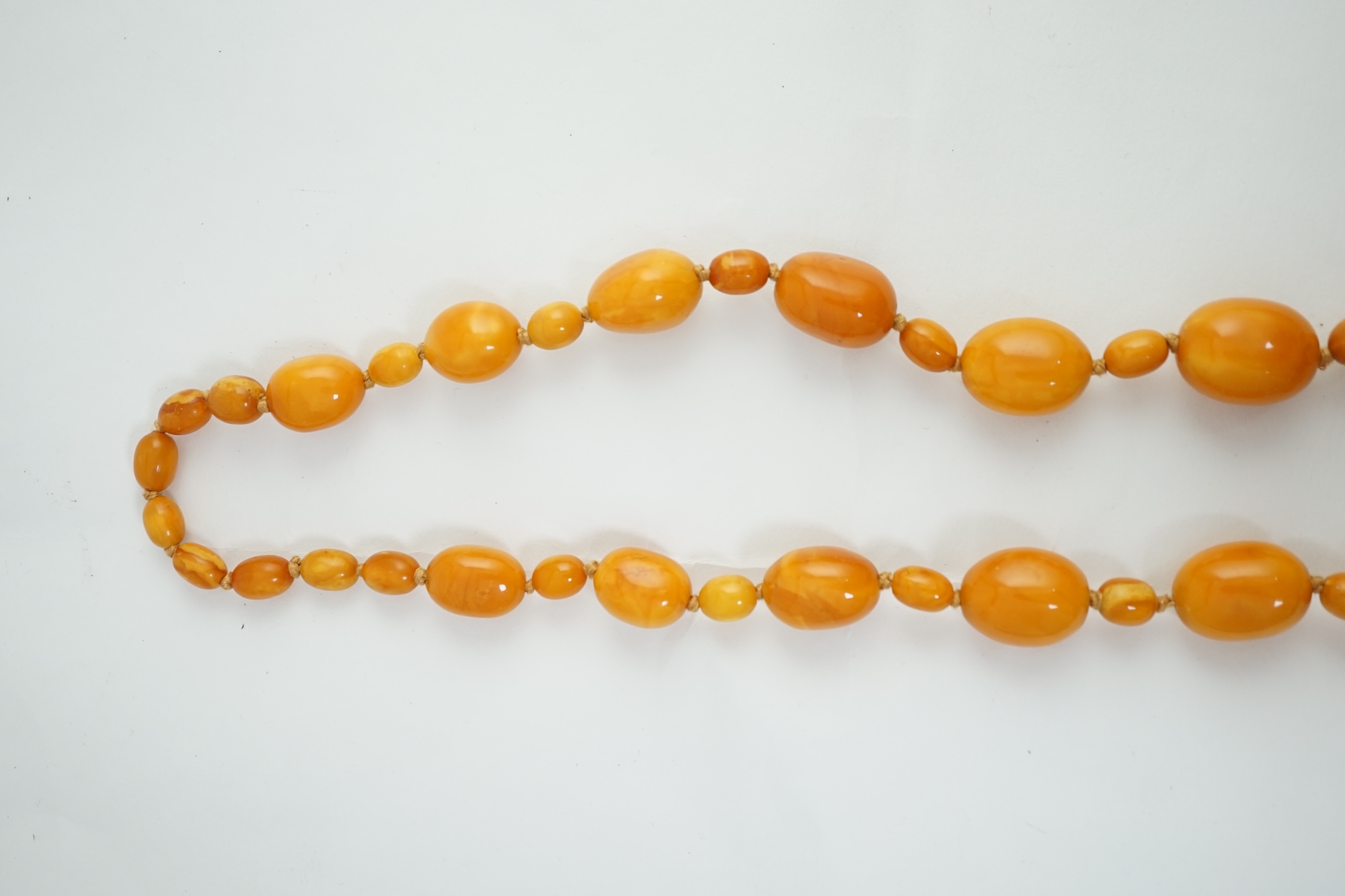 A single strand graduated oval amber bead necklace, with small amber bead spacers